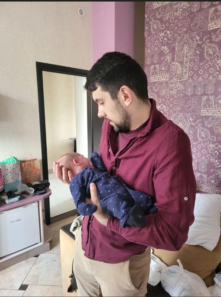 Andrew Khodonovych tenant un nouveau-né — un moment d'un parcours de GPA Novaparent en Ukraine